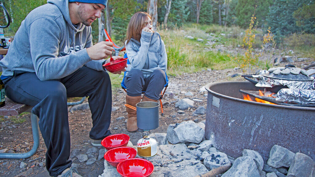 couple in front of camp fire at lehman creek campground