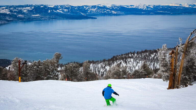 skier at heavenly with tahoe in background
