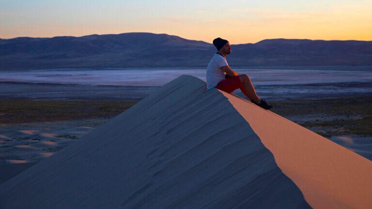 man overlooking the dunes at sand mountain