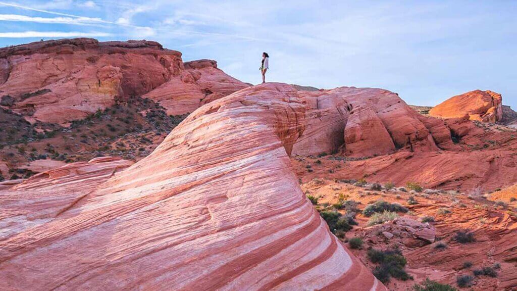 woman standing atop rock formation at valley of fire state park