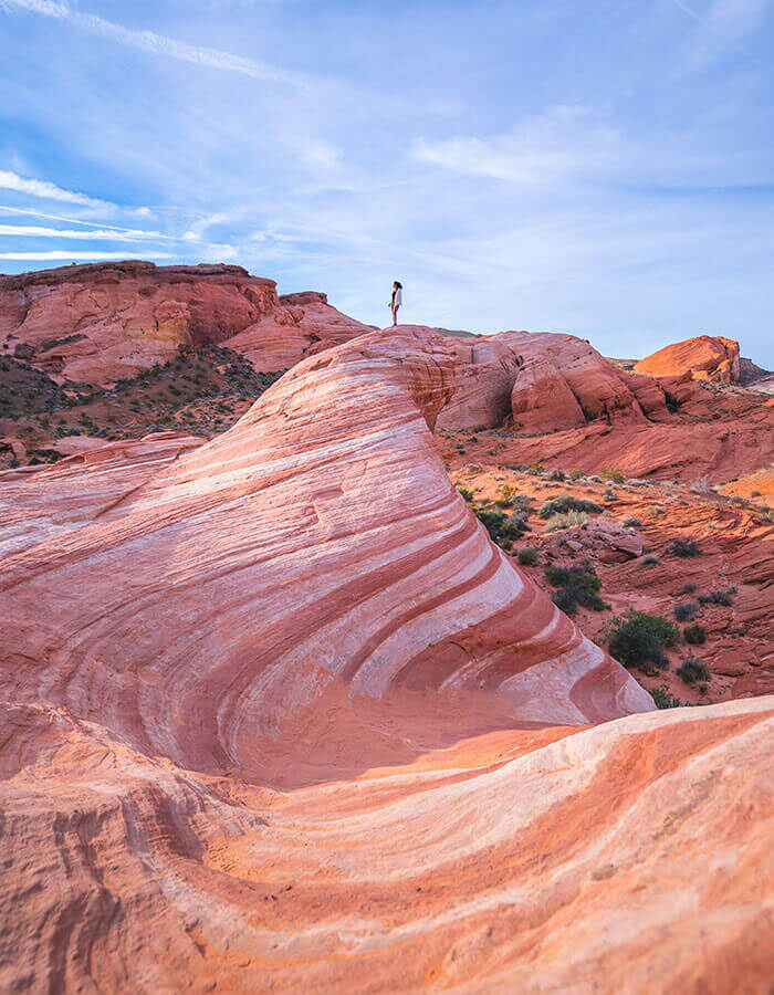 woman standing atop rock formation at valley of fire state park
