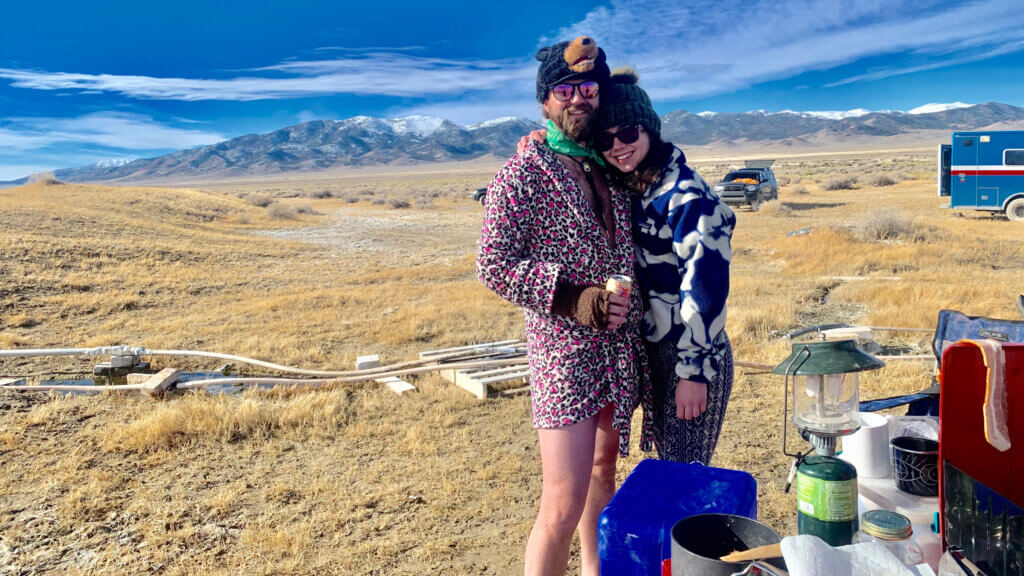 couple wearing robes outside hot spring