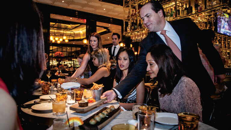 man serving a table of women on a lip smacking foodie tour