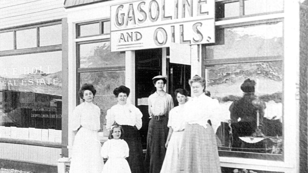 women standing in front of rhyolite gasoline and oil store