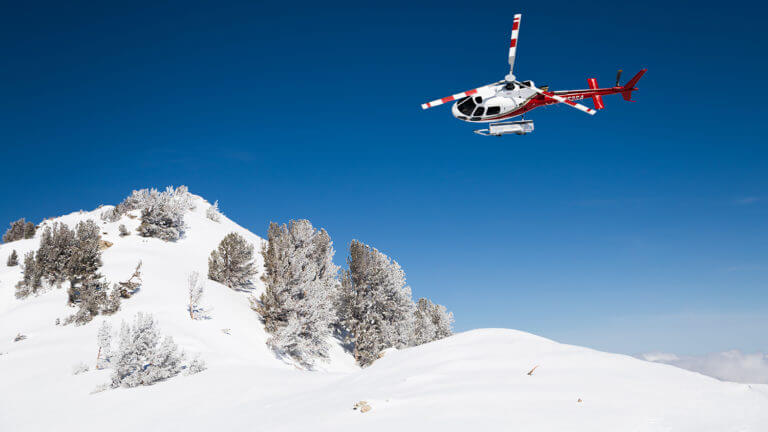 helicopter flying over ruby mountain for cat skiing