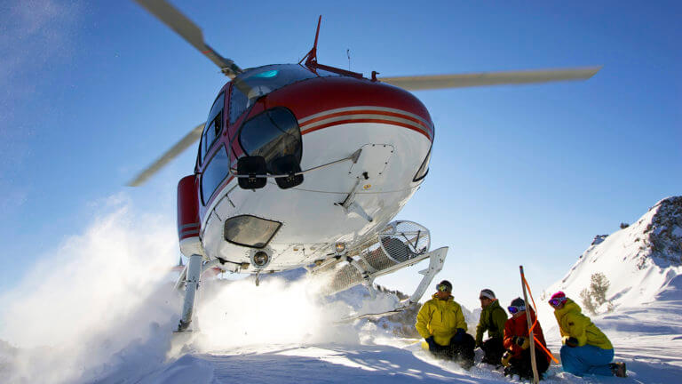 helicopter flying over snow pack