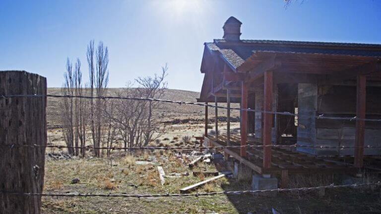 barbed wire fence surrounding old building in unionville ghost town