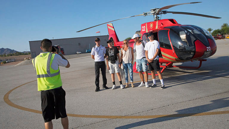 family posing with pilot after helicopter tour