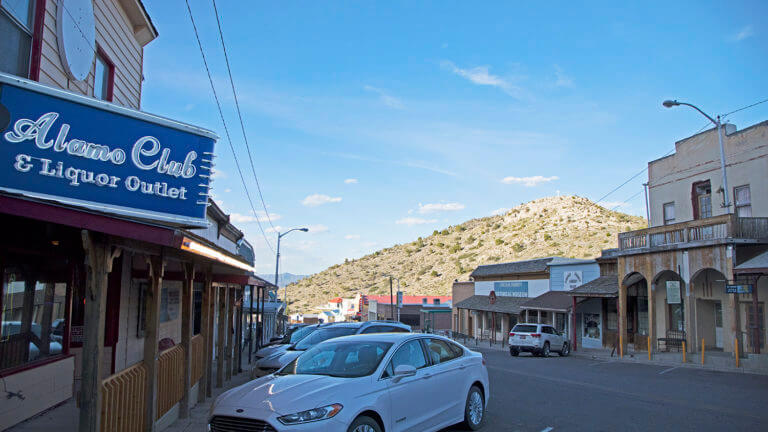 cars parked in front of the the alamo club & liquor outlet