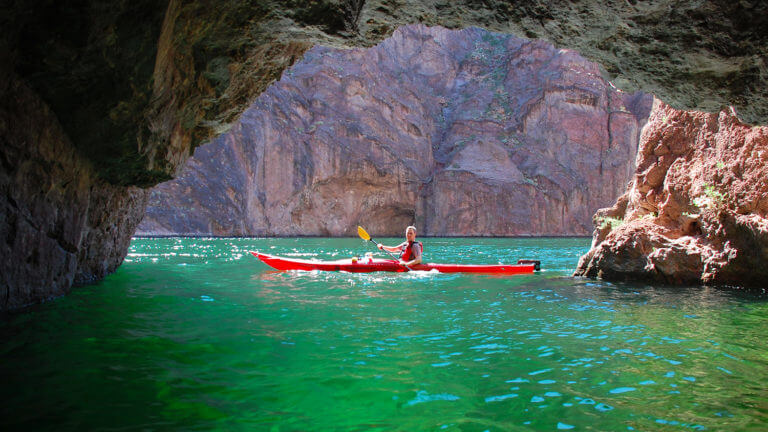 kayaker outside of a cave