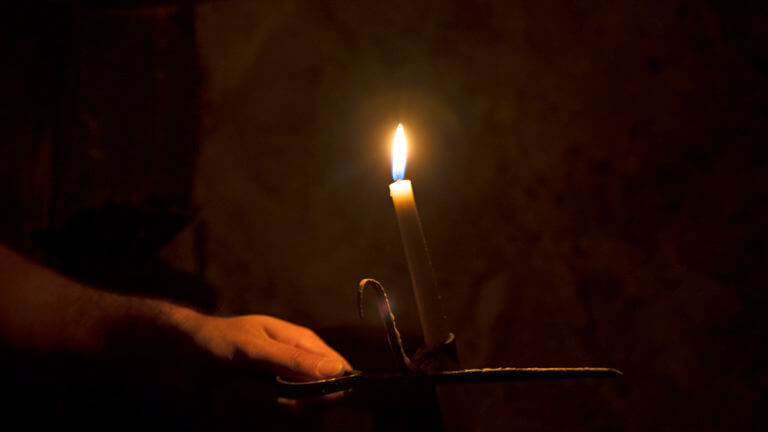 candle being held inside chollar mine