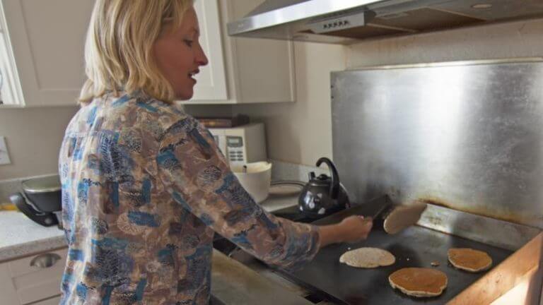 woman cooking pancakes at the pine tree inn and bakery