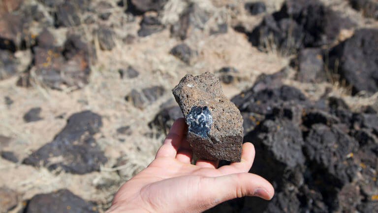 hand holding obsidian rock