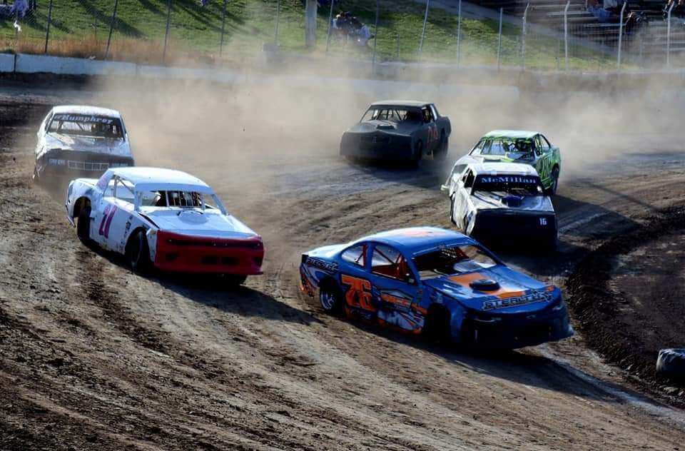 Cars driving on dirt raceway