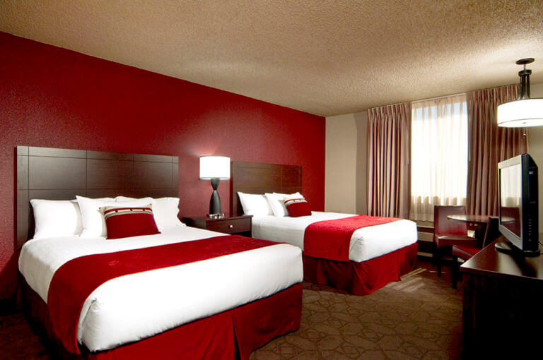 two beds with red accents in a room at edgewater casino resort