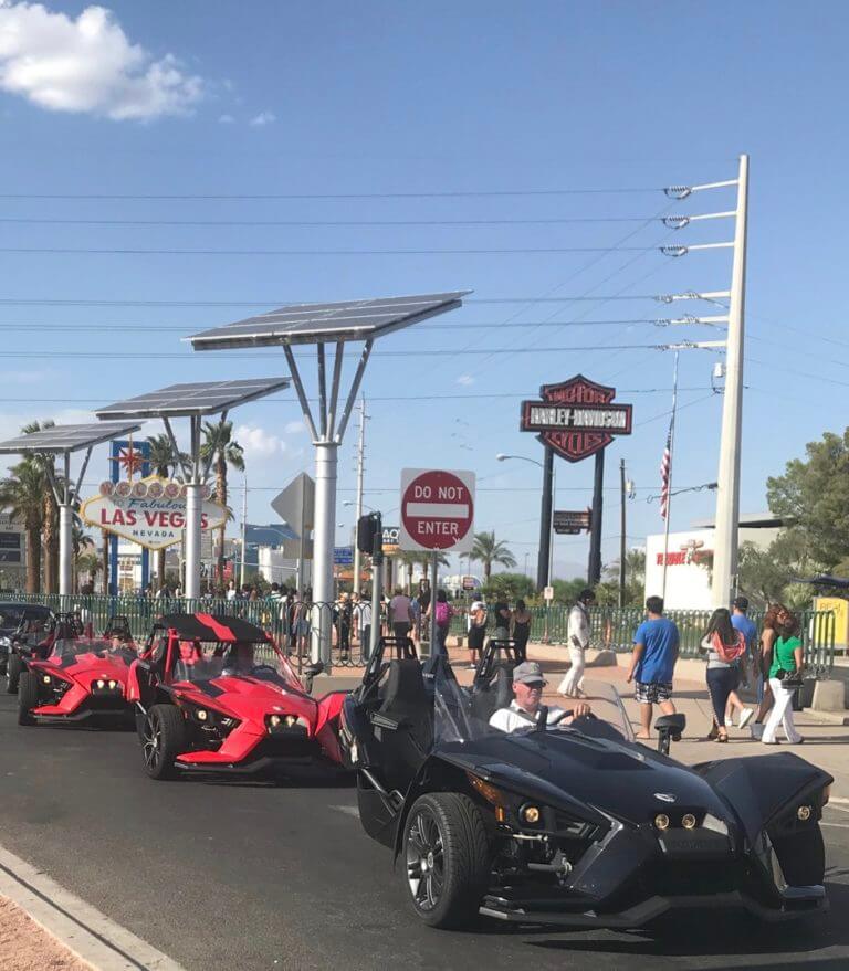 slingshots in front of the Las Vegas sign
