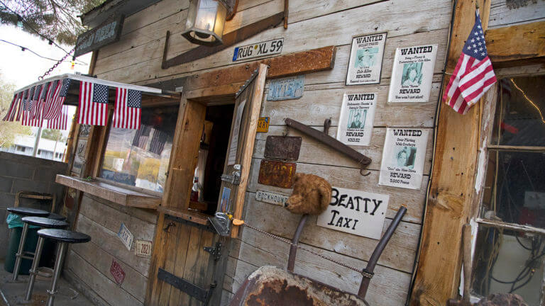 beatty taxi sign and small american flags hanging over a window outside of the happy burro