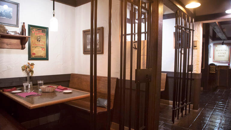 row of tables behind bars at cellblock steakhouse