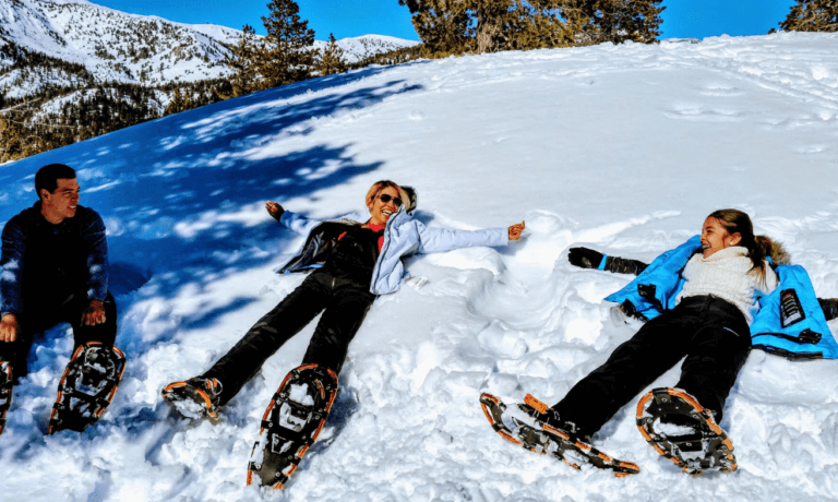 family laying down on snow on tahoe