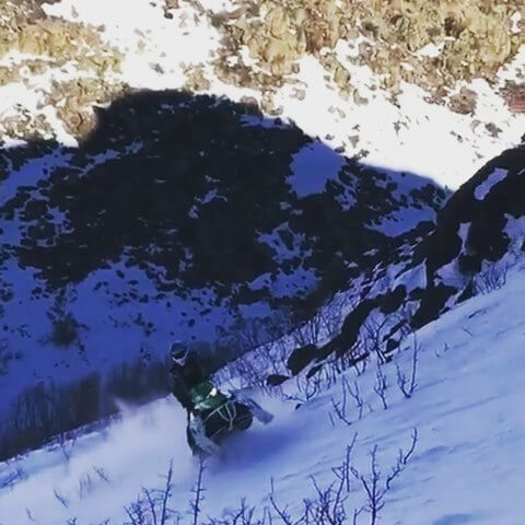 snowmobile riding up a mountain
