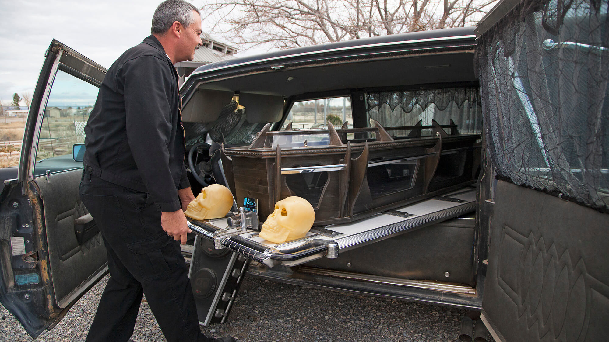 man loading coffin into a car