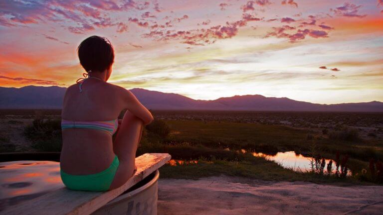 woman watching the sunset at spencer hot springs
