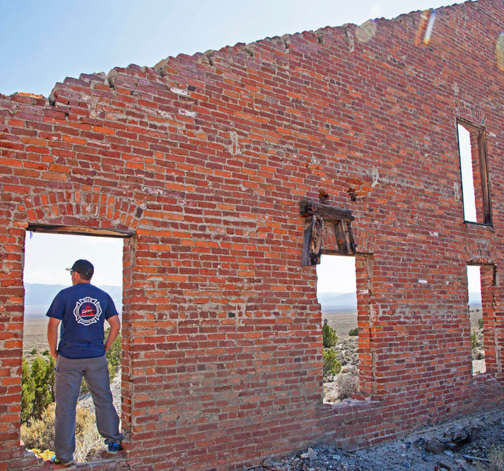 man standing in belmont ghost town ruins