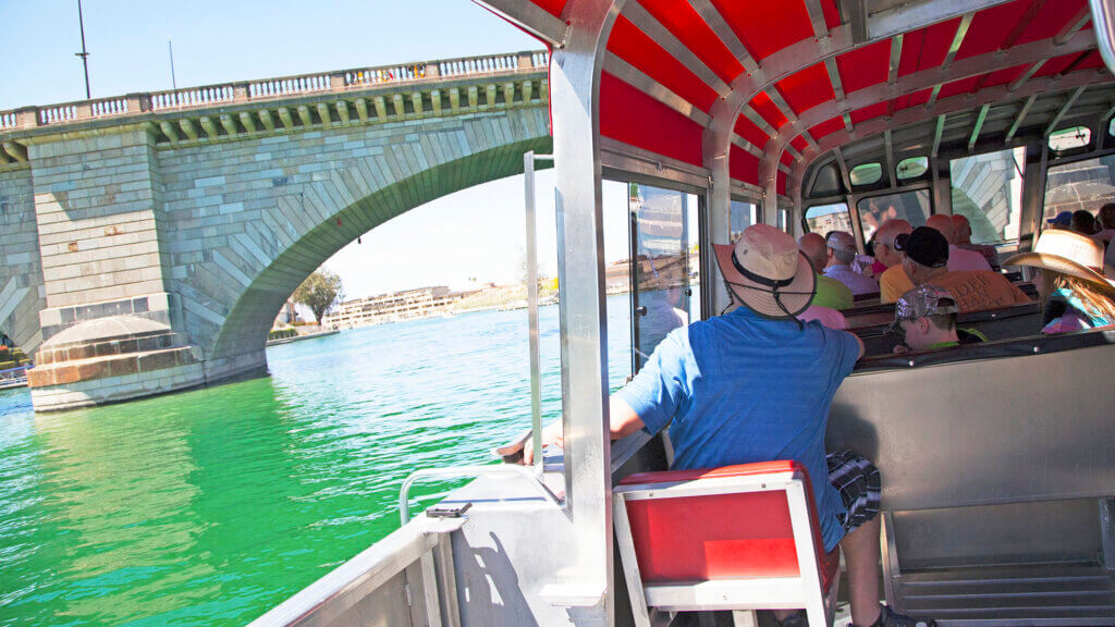 tour boat full of people going under the london bridge