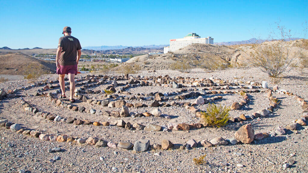 man walking over rock formation at laughlin labyrinths