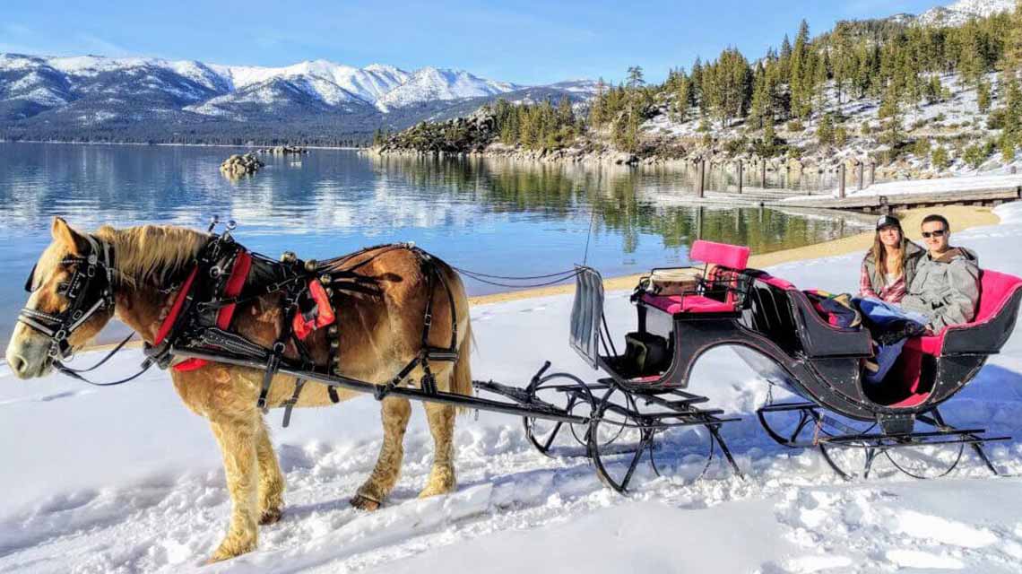 couple in horse drawn sleigh at sand harbor lake tahoe