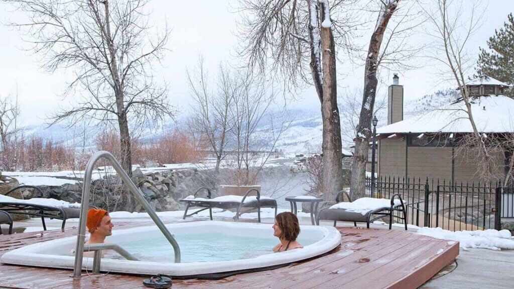 couple inside hot spring at david walleys resort on winter day