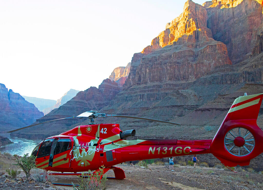 red papillon helicopter on the bottom of the grand canyon