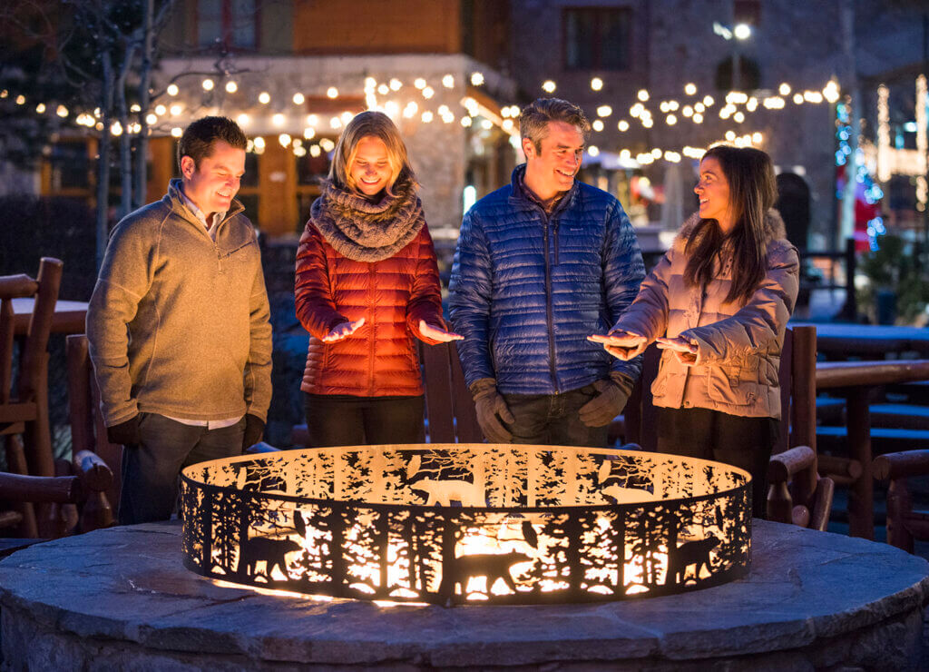 4 people enjoying south lake tahoe nightlife in front of a fire pit