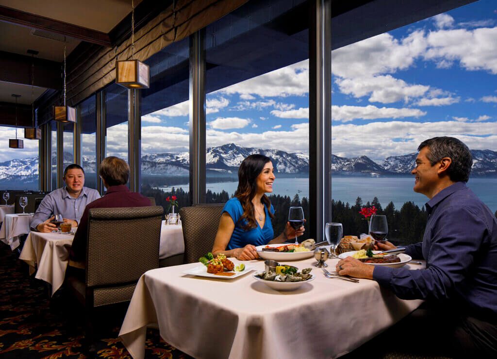 a couple enjoys the view of lake tahoe from their restaurant table