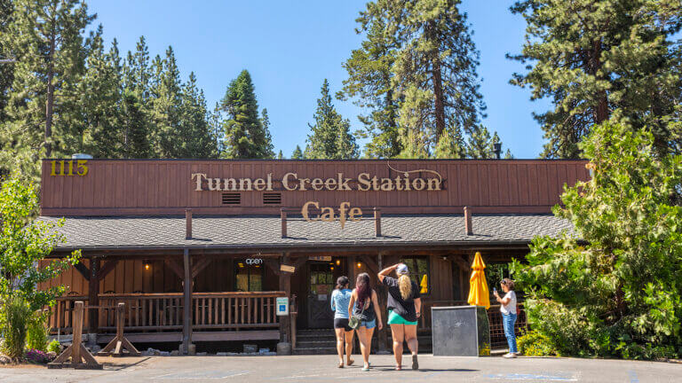 group of people standing in front of the tunnel creek cafe