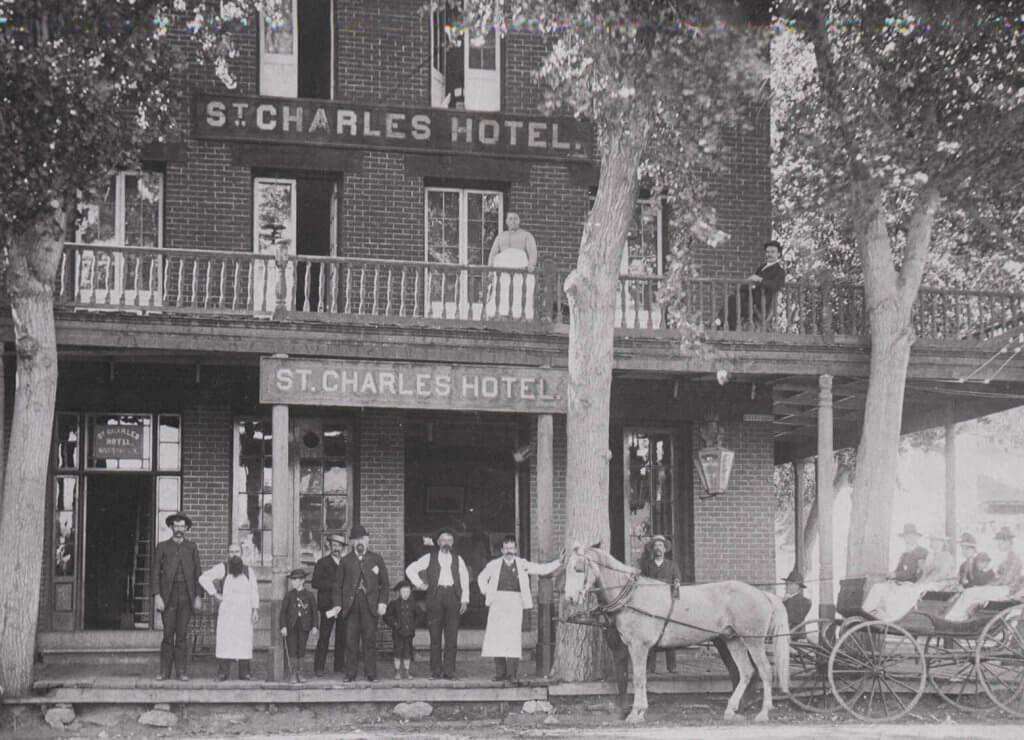 black and white image of a group of people and horse drawn wagon in historic carson city