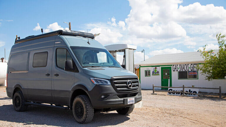 van parked in front of alien cowpoke gasoline and general store