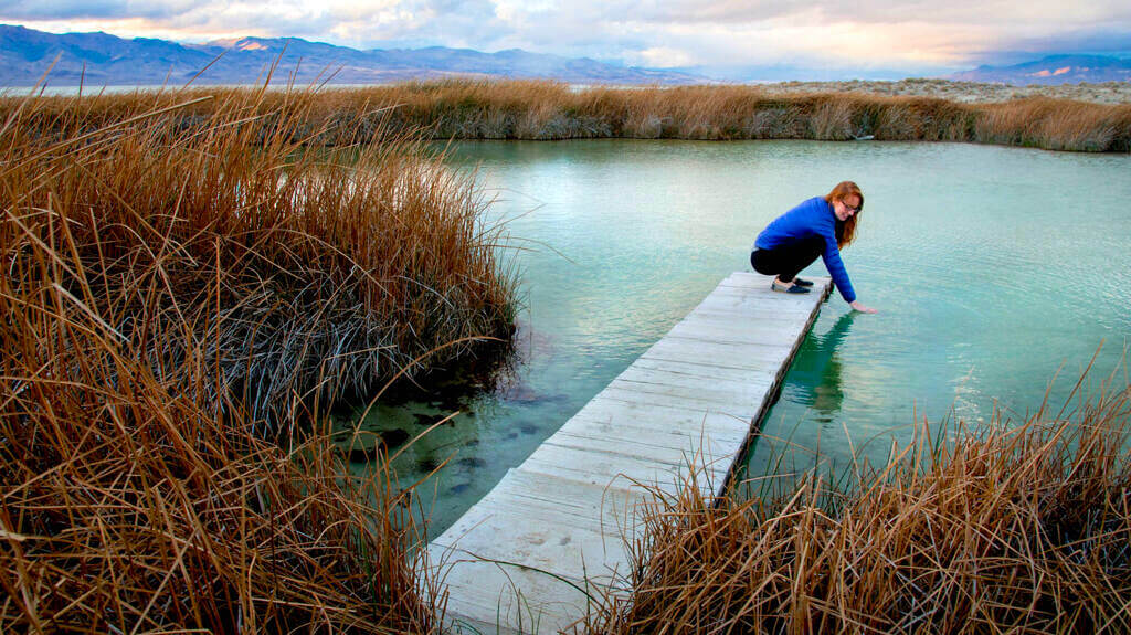 woman testing waters at black rock hot springs