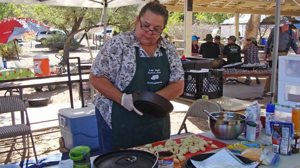 woman cooking at dutch oven cookoff event