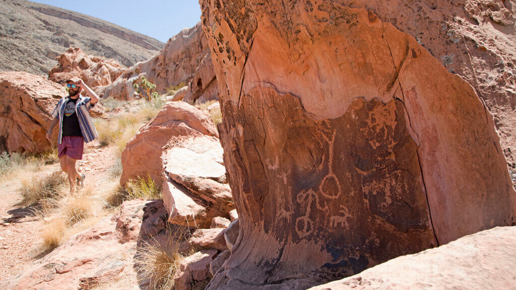 visitor exploring gold butte wall drawings