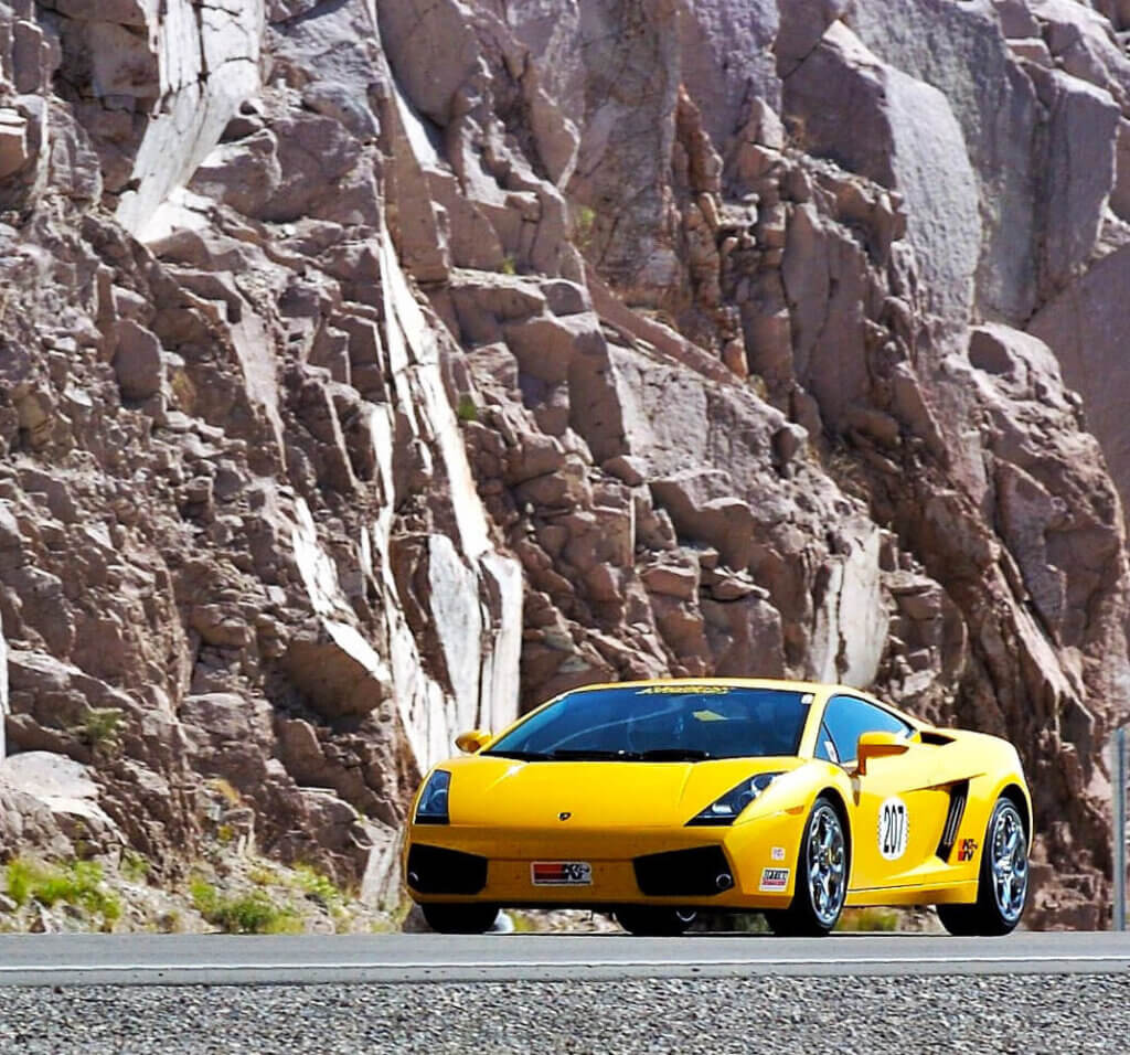 yellow lamborghini parked in front of a mountain