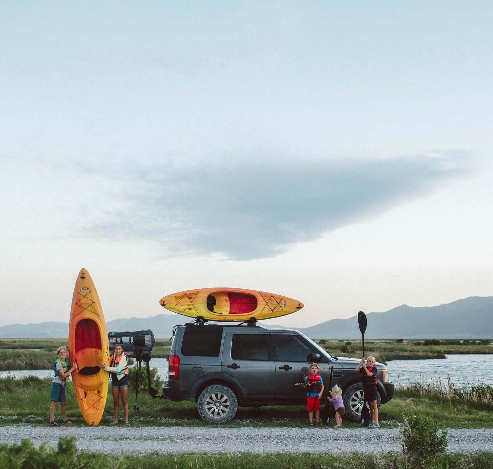 Family with a car that has kayaks on it.