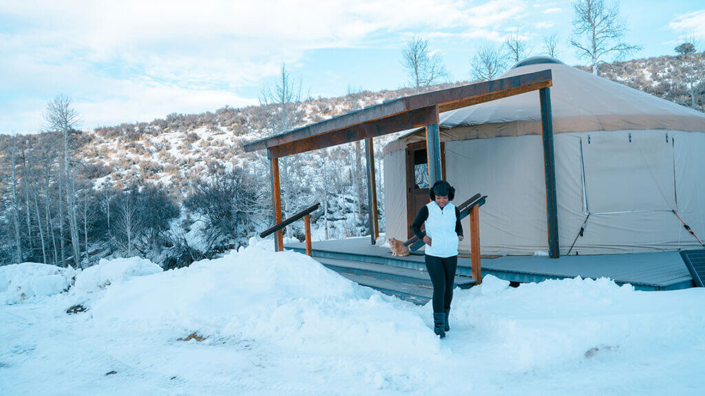 a woman and a cat outside the ruby high yurt in lamoille nv