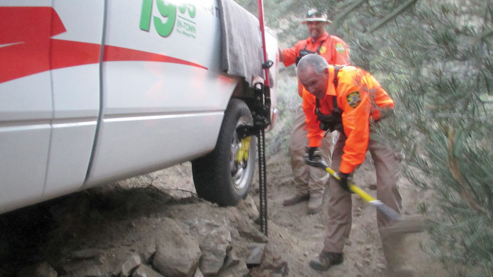 Search and Rescue members digging out a stuck rental vehicle