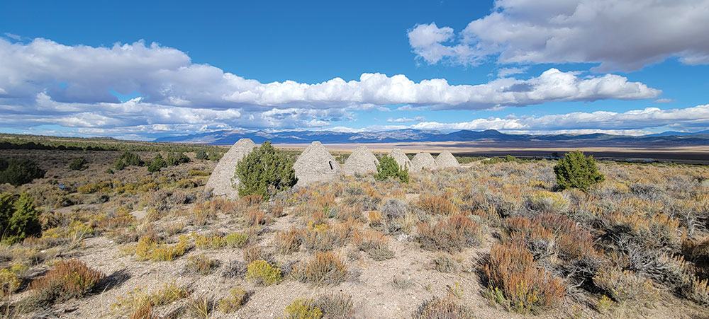 Ward Charcoal Ovens State Park - stone charcoal ovens, shaped like upside-down beehives, in the middle of the desert with mountains in the distance.