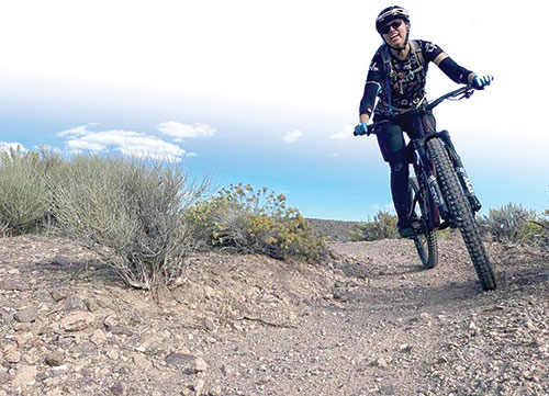 A happy mountain biker rides a dirt trail on Ward Mountain