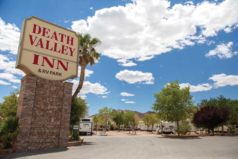 Death Valley Inn & RV Park sign with RVs in the background.