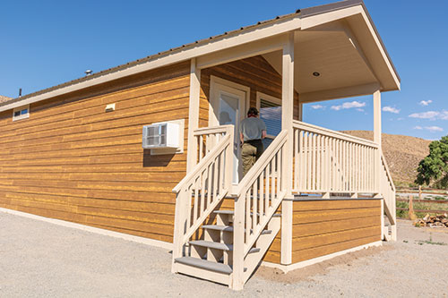 A person walks into a cabin from the outside.