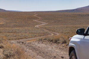 Dirt road stretched in front of a car.