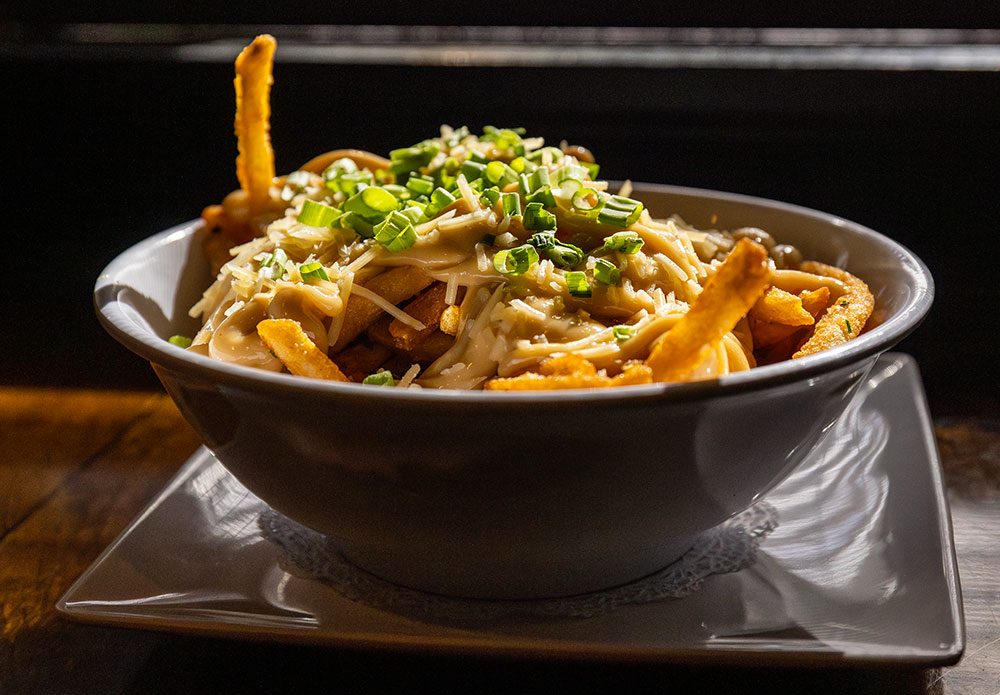 Gangster fries: Bowl of french fries with garlic aioli, parmesan, and chives on top